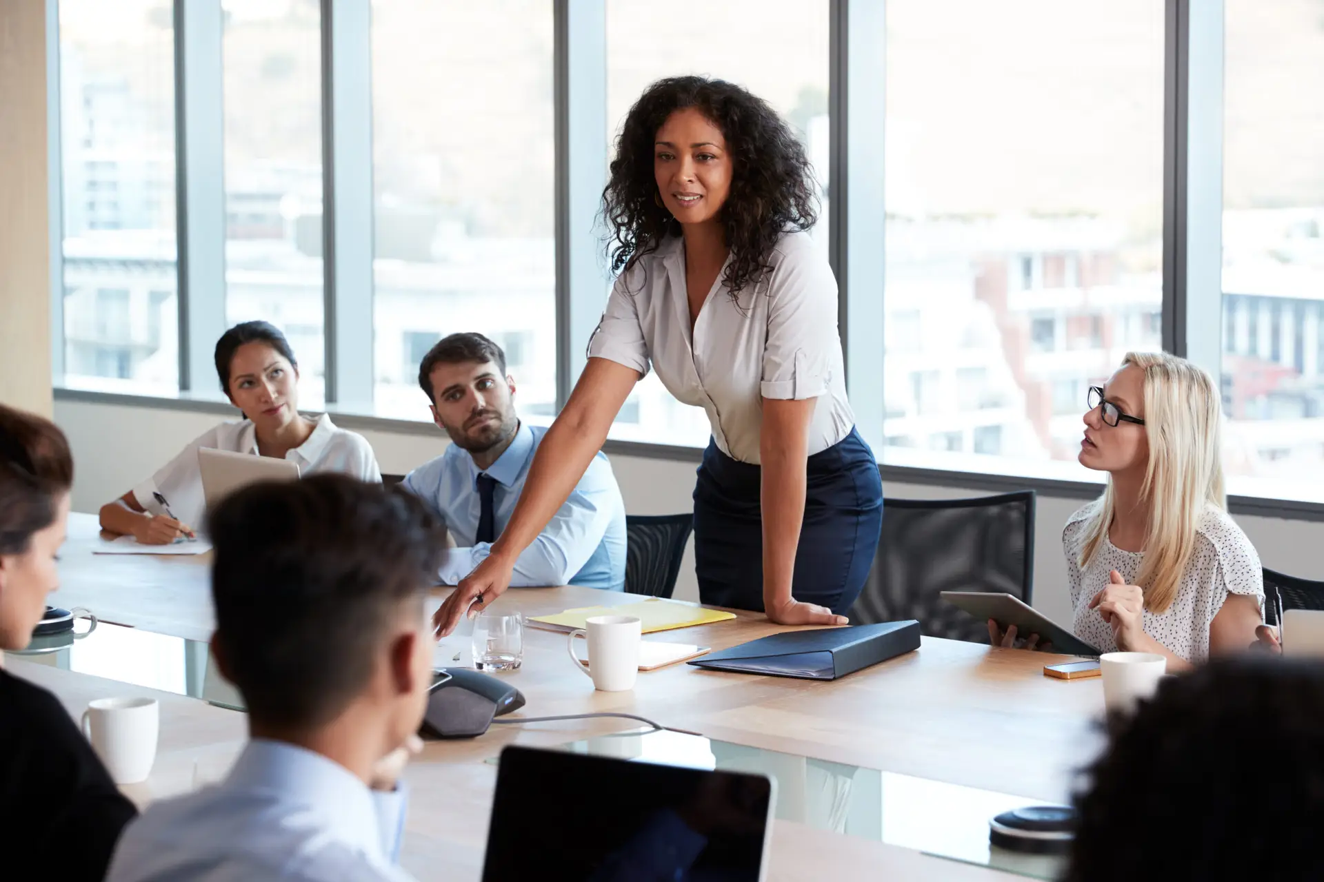 Woman chairing a meeting around a boardroom table