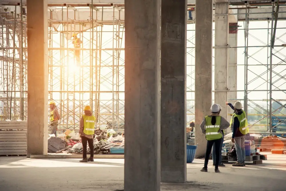 Construction site with scaffolding and people with hi-vis jackets on