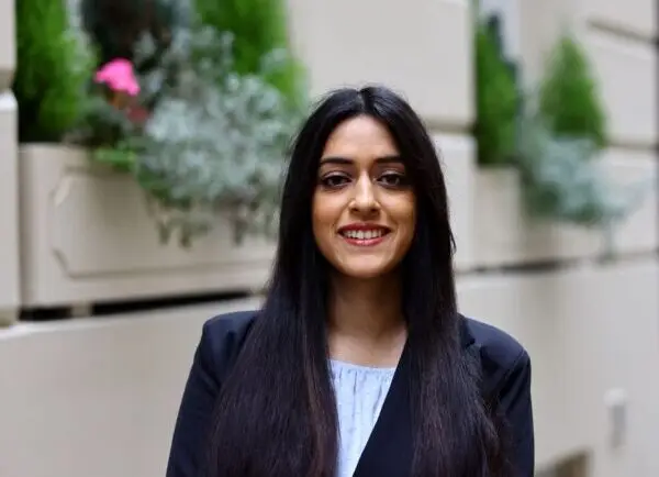 Diva Gaur. Female with long brown hair in business suit