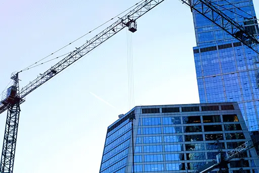 Cranes over glass buildings